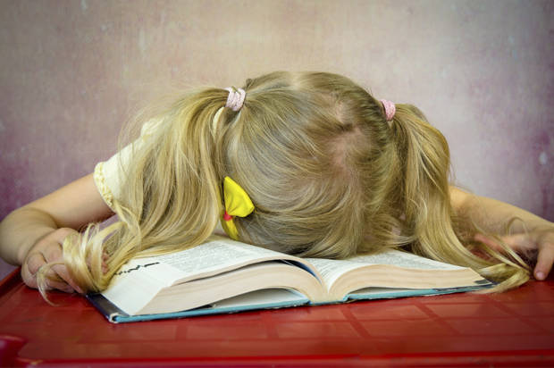 blond girl sleeping over open book